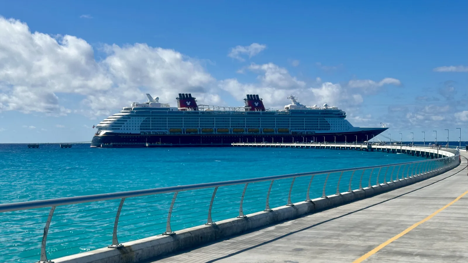 The Disney Dream berthed at the Lookout Cay pier, shallow turquoise water on both sides of the walkway