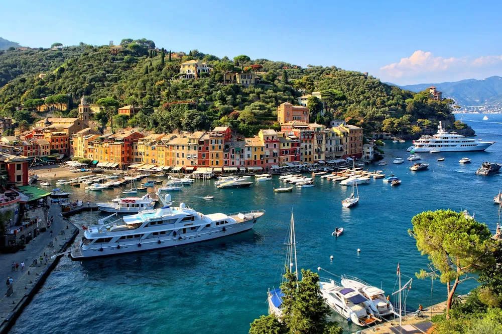 The harbour at Portofino on the Italian Riviera, pastel houses above a bay full of moored boats